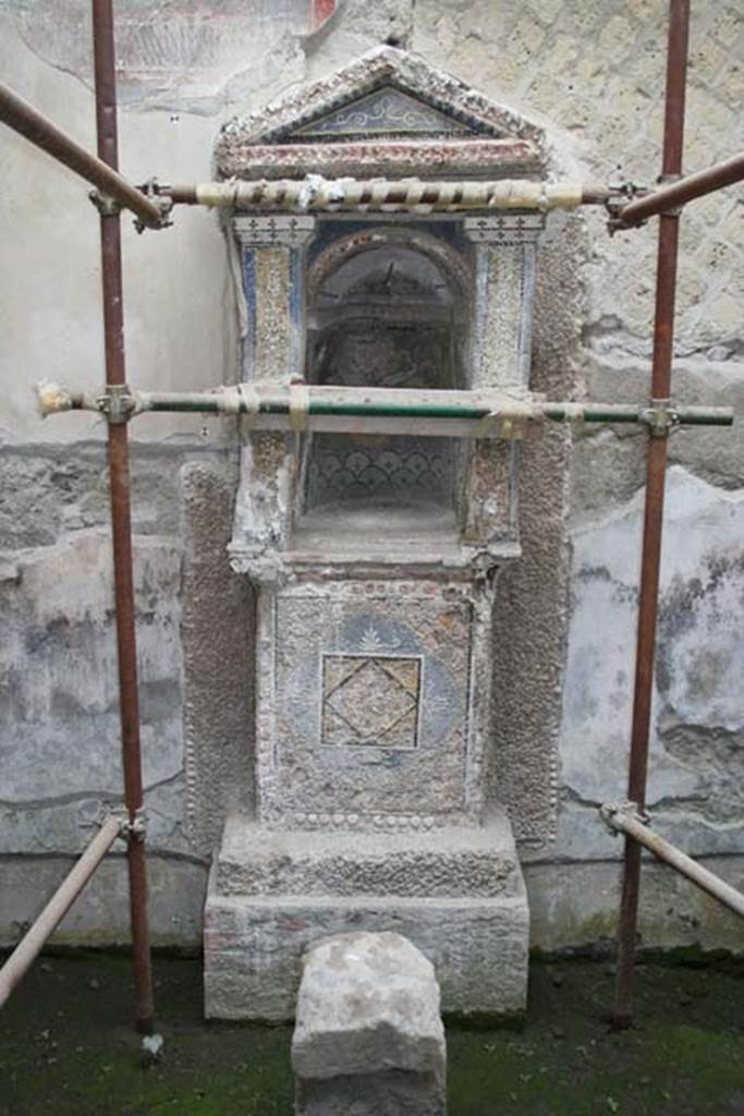 III.3 Herculaneum. March 2008. Mosaic and shell-trimmed aedicula built on a high podium against the wall.
Photo courtesy of Sera Baker.